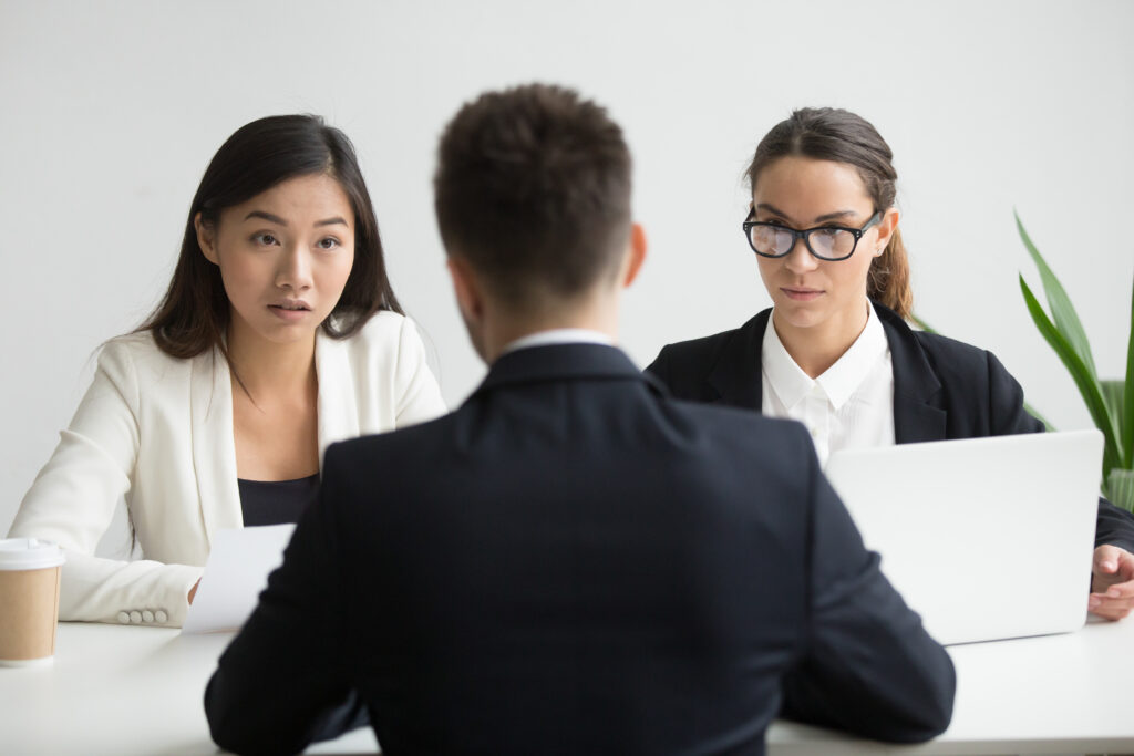 การสัมภาษณ์งานไม่ใช่คำตอบเดียว: วิธีลดความเสี่ยง “จ้างผิดคน” 2 serious unconvinced diverse hr managers interviewing male job applicant 3